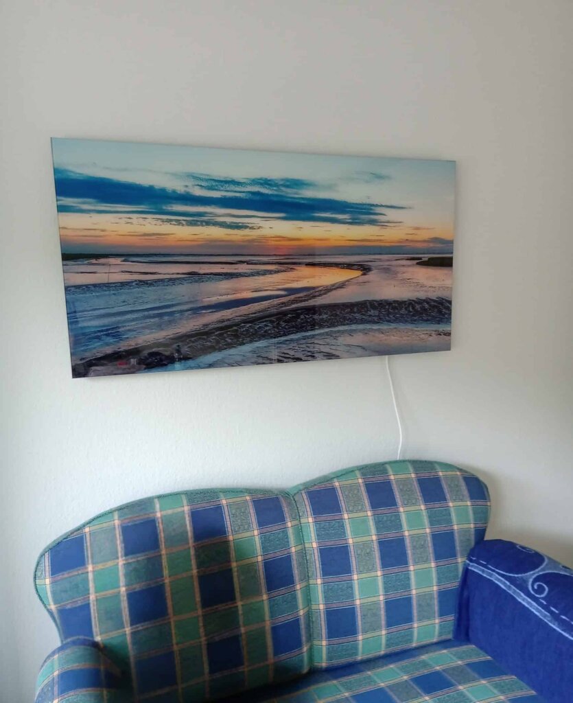 Rahmenlose Glasbildheizung mit Strand- und Sonnenuntergangsmotiv im Gästezimmer