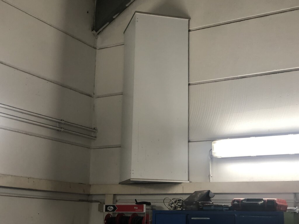 Photonenheizung Gewerbeheizung in Dreiecksform, weiß, Seitenansicht in Autowerkstatt mit hohen Decken.