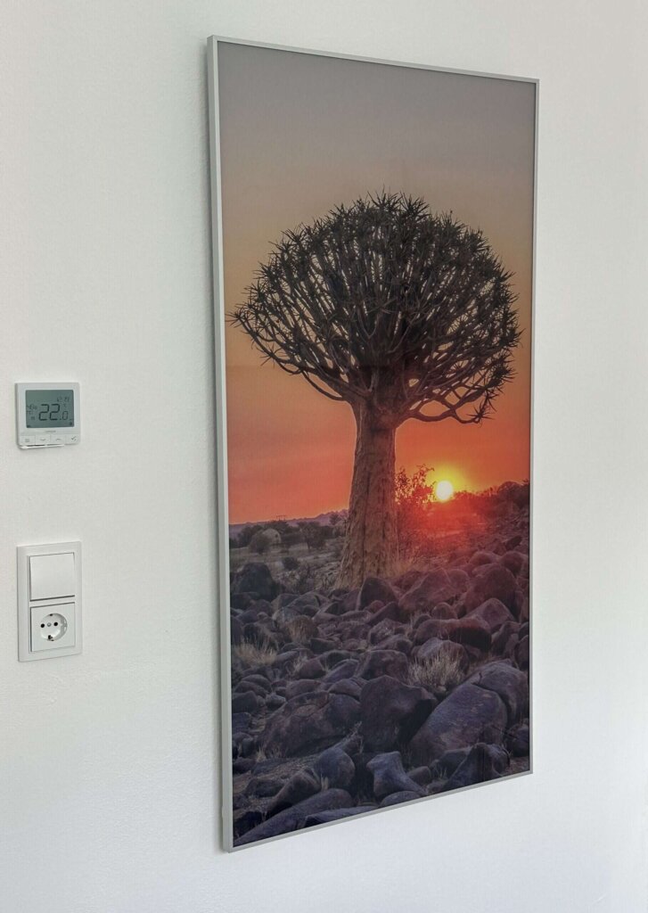 Glasbildheizung mit Baum im Sonnenuntergang und mattem Silberrahmen