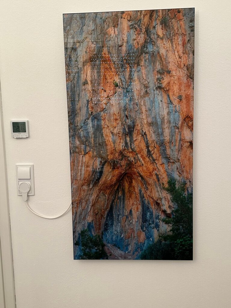 Rahmenlose Glasbildheizung mit Felsen und Bäumen in der Frontansicht
