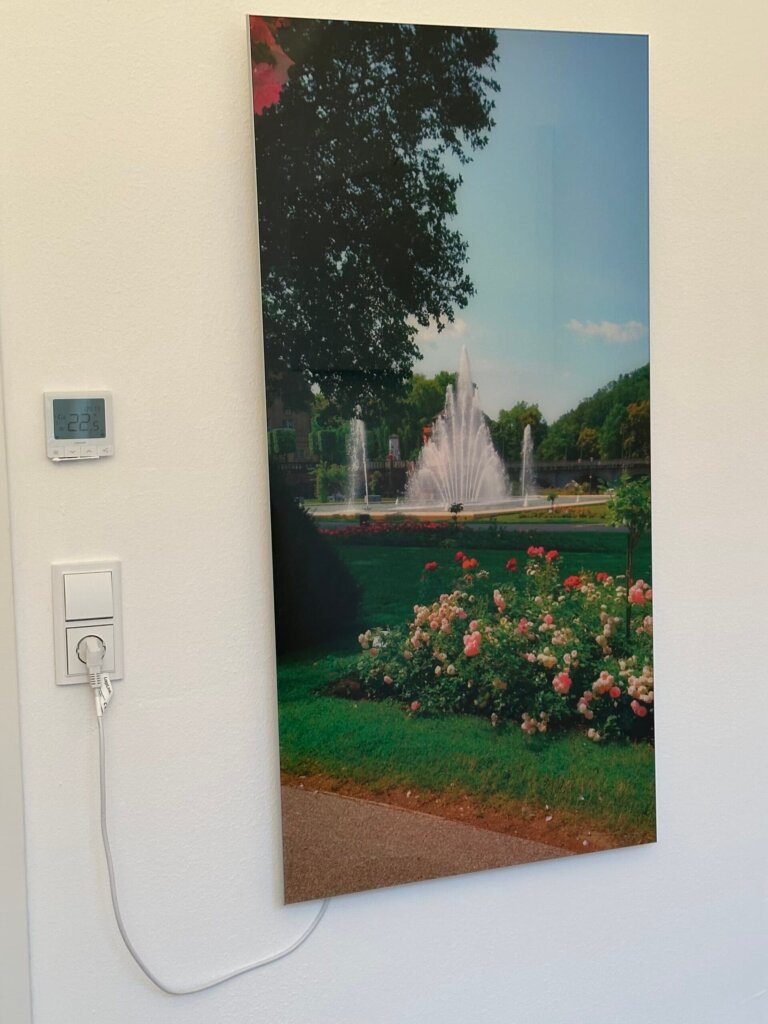 Rahmenlose Glasbildheizung mit Park- und Brunnenmotiv