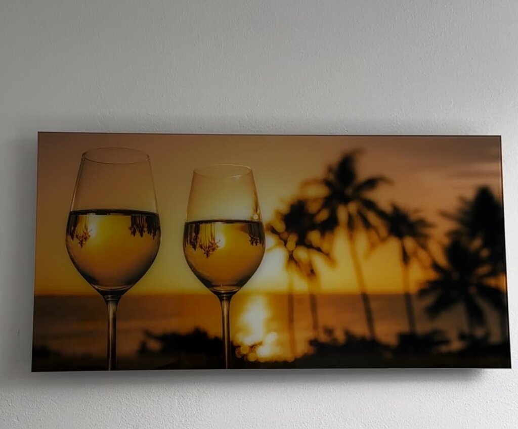 Rahmenlose Glasbildheizung mit Weingläsern und Sonnenuntergang in der Ausstellung