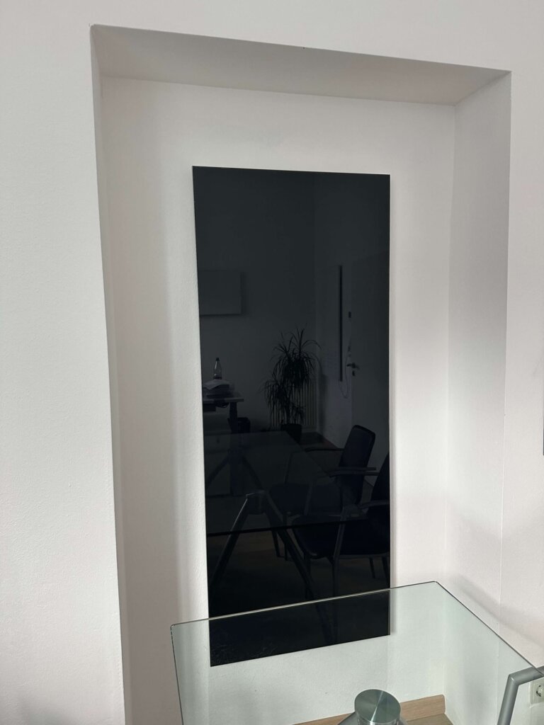 Schwarze rahmenlose Photonenheizung Glasheizung im Büro