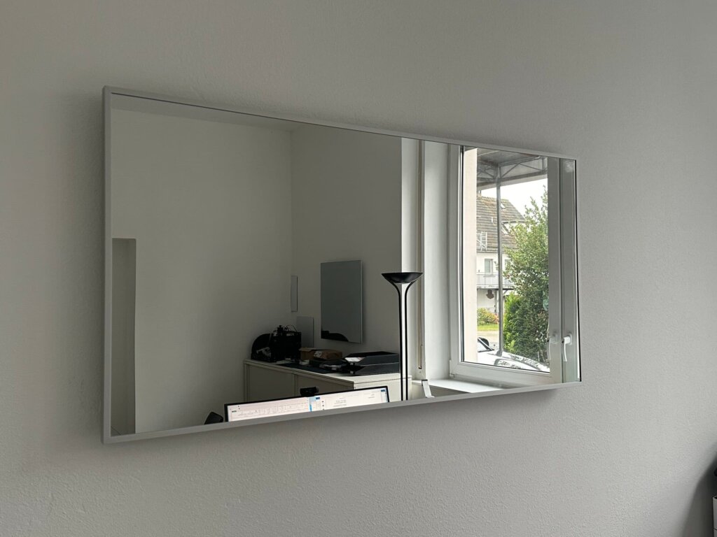 Photonenheizung Spiegelheizung mit mattem Silberrahmen, moderner Raum